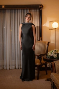 Détail d'une robe de soirée en satin noir avec épaules cape et silhouette élégante