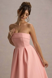 Détail de la robe de soirée rose sans bretelles montrant le satin et la jupe plissée