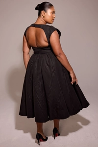 Detail of a backless black maxi dress featuring elegant textured jacquard fabric