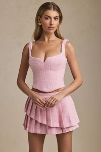 Detailed texture of pink tweed two-piece set featuring corset top and pleated mini skirt