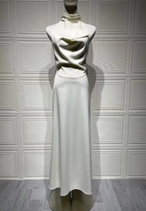 Detail of white satin halter maxi dress showing cowl neck draping and silky texture