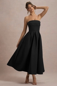 Détail de la jupe plissée taille haute et du tissu satiné de cette robe bustier noire