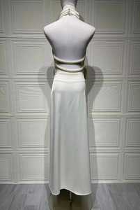 Detail of white satin backless dress featuring elegant double-row pearl chain back straps