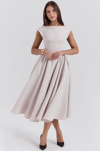 Detail of elegant backless A-line sleeveless dress in soft beige with flowing pleated skirt