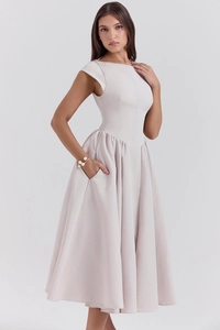 Detail of elegant backless sleeveless dress featuring pleated waist and side pockets