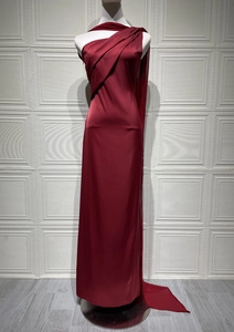 Detail of the asymmetrical pleated shoulder and long cape on a satin evening gown