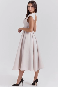 Detail of elegant backless cutout and pleated hem on a minimalist pale pink sleeveless dress