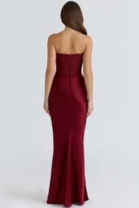 Detail of dark red strapless fishtail dress featuring a sleek back zipper and satin finish