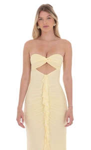 Close-up of pale yellow tube dress showing front cutout and vertical ruffle detail