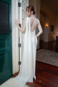 Elegant back view of cream satin evening gown with open back and draped shoulder detail