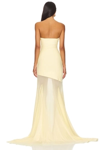 Detail of elegant cream yellow strapless dress showing asymmetric sheer tulle train and draping