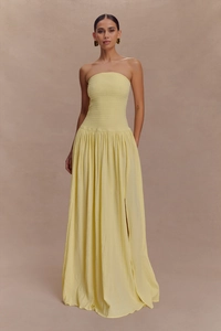 Détail du bustier froncé et fente latérale sur une robe longue jaune sans manches