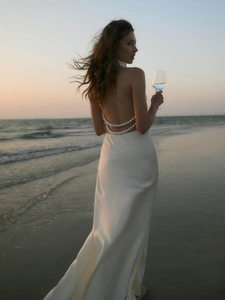 White satin backless maxi dress with pearl chain details on back for summer beach sunset