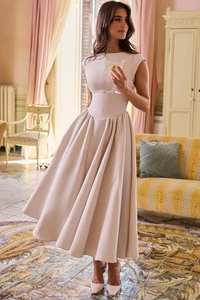 Detailed view of elegant beige high-waisted dress with voluminous pleated skirt