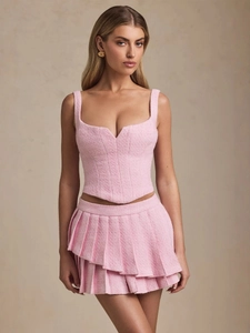 Pink tweed two-piece set featuring corset-style camisole top and pleated mini skirt