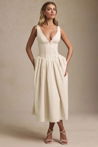 Dettaglio dell'elegante abito midi in pizzo ricamato crema con scollo a V e fiocco
