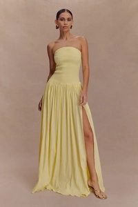 Détail de robe longue bustier jaune clair froncée avec une fente latérale haute