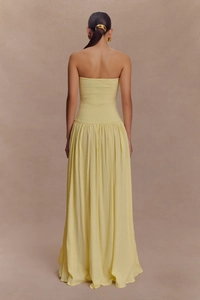 Détail du bustier froncé élastique et du tissu fluide d'une robe longue dos nu jaune clair