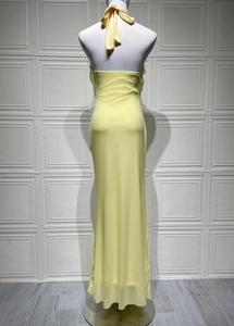 Detail of light yellow backless maxi dress with halter neck tie and sheer fabric texture