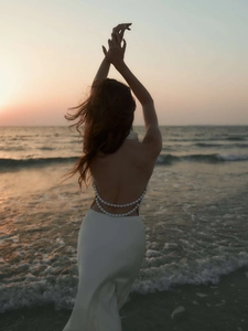 Detail of elegant open back with crisscross pearl straps on a white satin dress