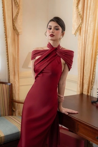 Detail view of burgundy satin dress showing halter-neck cross-wrap and silky texture