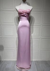 Close-up of pink sequined halter neck detail and smooth satin fabric on evening dress
