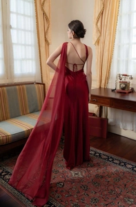 Detailed back view of a dark red satin mermaid gown with lace-up straps and a long shawl