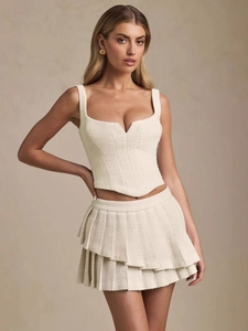 Chic cream tweed two-piece set featuring a cropped camisole top and pleated mini skirt