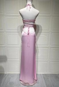 Detail of light pink satin dress showing intricate criss-cross tie-back and open back design