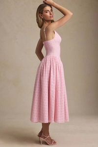 Dettaglio di un abito midi rosa ricamato con spalline sottili e vita a pieghe