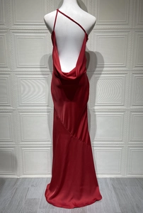 Detail of red satin evening gown showing low back drape and silk texture on a mannequin