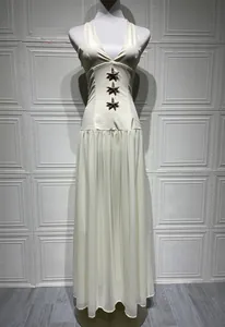Detail of three starfish appliques on a white halter neck maxi dress with chiffon skirt