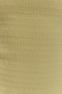 Gros plan détaillé du tissu smocké jaune clair montrant la texture élastique