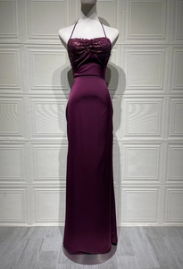 Detail of dark purple sequined bodice and pleated satin fabric on a slim evening gown