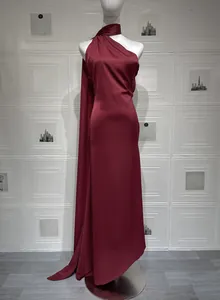 Détail de la robe en satin bordeaux avec col licou et texture drapée plissée élégante