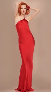 Close-up of the elegant glossy red satin fabric and twisted shoulder detail on the dress