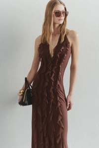 Detail view of the chocolate brown halter dress featuring tiered ruffles and a deep V-neckline