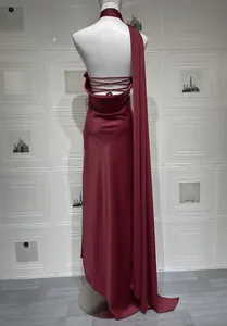 Détail d'une robe de soirée dos nu en satin bordeaux avec brides croisées et ruban long