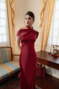 Detail showing the elegant halter neck and pleated satin fabric of this red evening gown