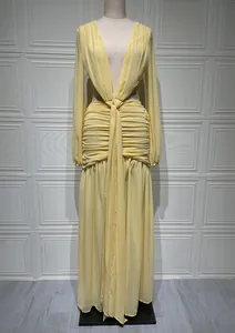 Dettaglio di un abito in chiffon giallo chiaro con scollo a V, nodo in vita e pieghe