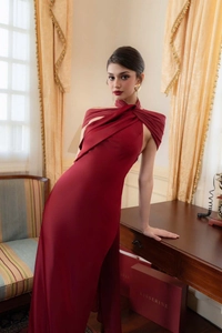 Detailed view of burgundy satin formal dress with halter twist neckline and high slit detail