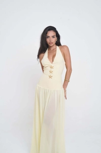 Detail of cream yellow halter dress featuring gold starfish embellishments and pleated skirt