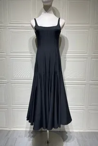Detail of square neck black camisole dress featuring pleated high-waisted design