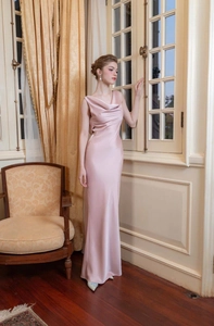 Détail du col bénitier élégant et du tissu en satin doux sur une robe de soirée rose