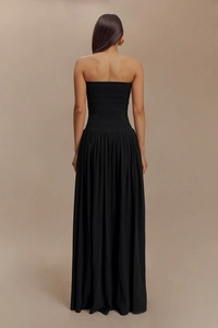 Détail de la robe longue dos nu noire avec bustier froncé et plis élégants