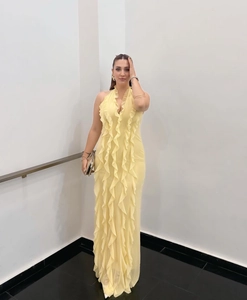 Detail of elegant yellow halter dress featuring cascading layered ruffles and slim fit