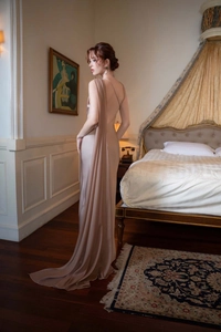 Detail of elegant champagne satin evening gown featuring one-shoulder draping and open back