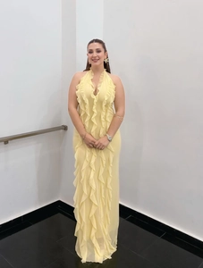 Detail of elegant yellow halter dress with layered ruffles and soft chiffon fabric