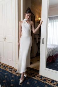 Gros plan sur le tissu en satin blanc élégant d'une robe de soirée formelle à dos nu