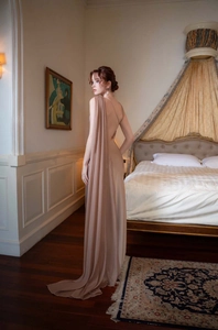 Detailed back view of champagne satin gown with elegant cape and deep V-back design